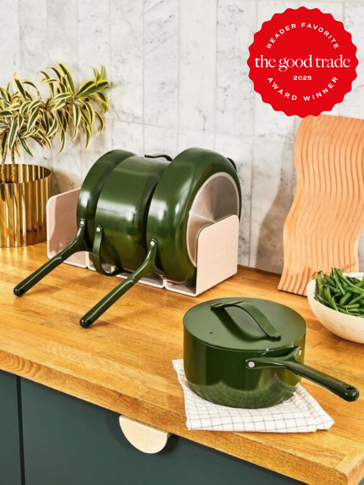 Green cookware set with lids and handles neatly stacked on a wooden kitchen countertop. A badge reads "Reader Favorite The Good Trade Award Winner 2023.