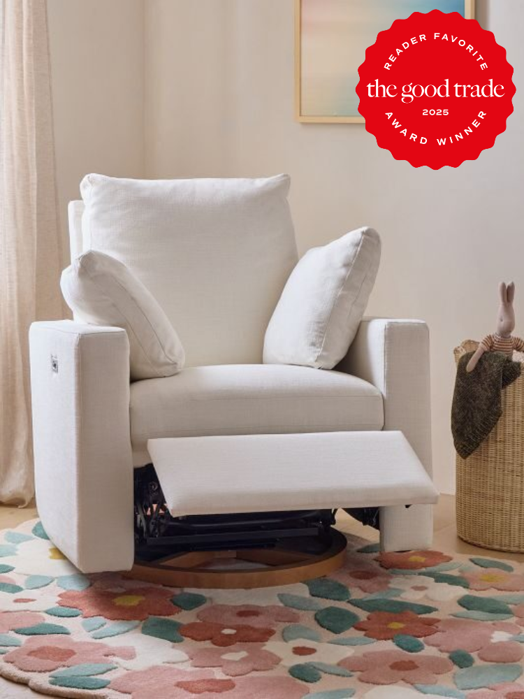 A white armchair with a reclined footrest on a colorful rug. A small stuffed toy sits on the chair's arm. A red award badge is displayed in the top corner.