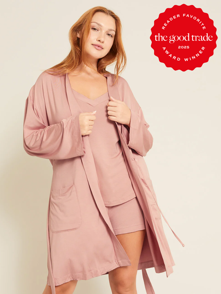 Person wearing a pink robe and matching loungewear, standing with one hand on hip. "The Good Trade 2025 Reader Favorite Award Winner" badge displayed.
