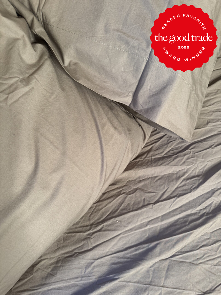 Wrinkled gray bed sheets with a red badge reading "Reader Favorite, The Good Trade, 2025 Award Winner" in the top right corner.