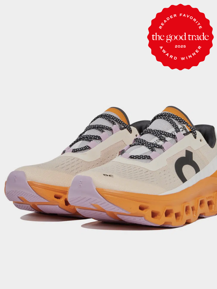 Pair of athletic shoes with beige uppers, black accents, purple soles, and orange midsoles. A "Reader Favorite" award badge from The Good Trade for 2025 is displayed in the top right corner.