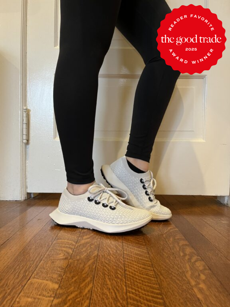 Person wearing white sneakers and black leggings stands on a wooden floor. A red badge reads "Reader Favorite, the good trade, Award Winner, 2025.