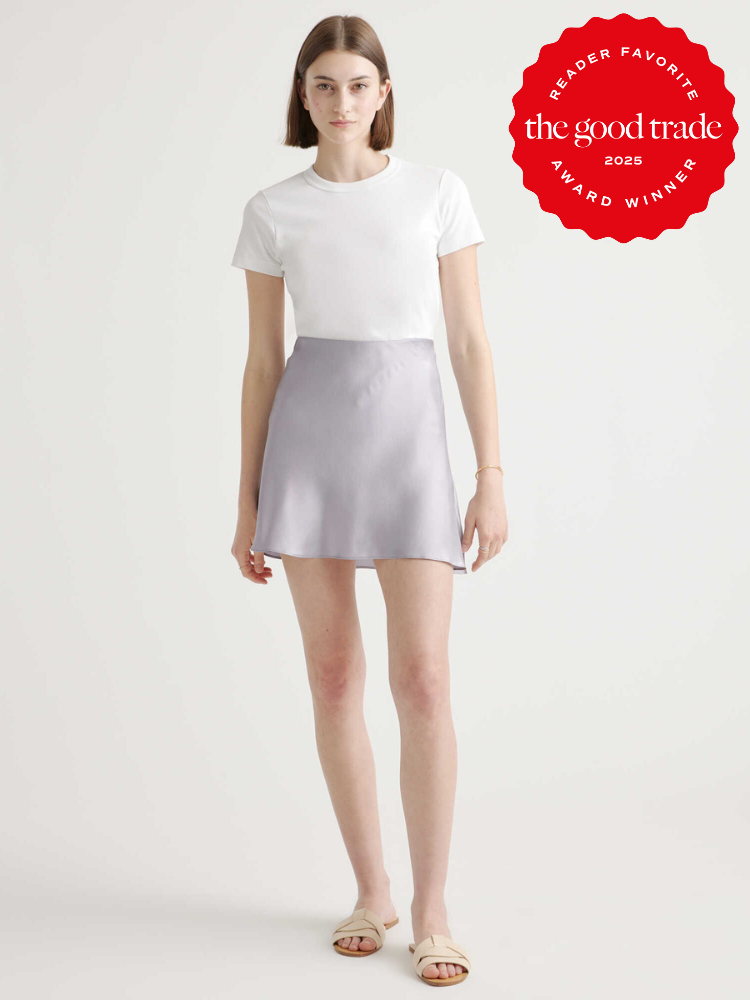 Person wearing a white top and light purple skirt stands against a plain background. A red award badge reading "Reader Favorite, The Good Trade, 2025 Award Winner" is displayed.