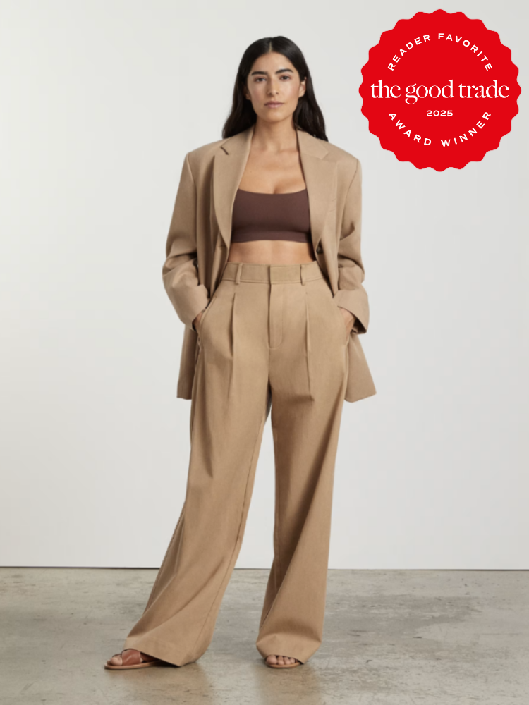 Person wearing a tan suit with a brown crop top stands in a neutral background. A red award badge for "The Good Trade Reader Favorite 2025" is displayed in the upper right corner.