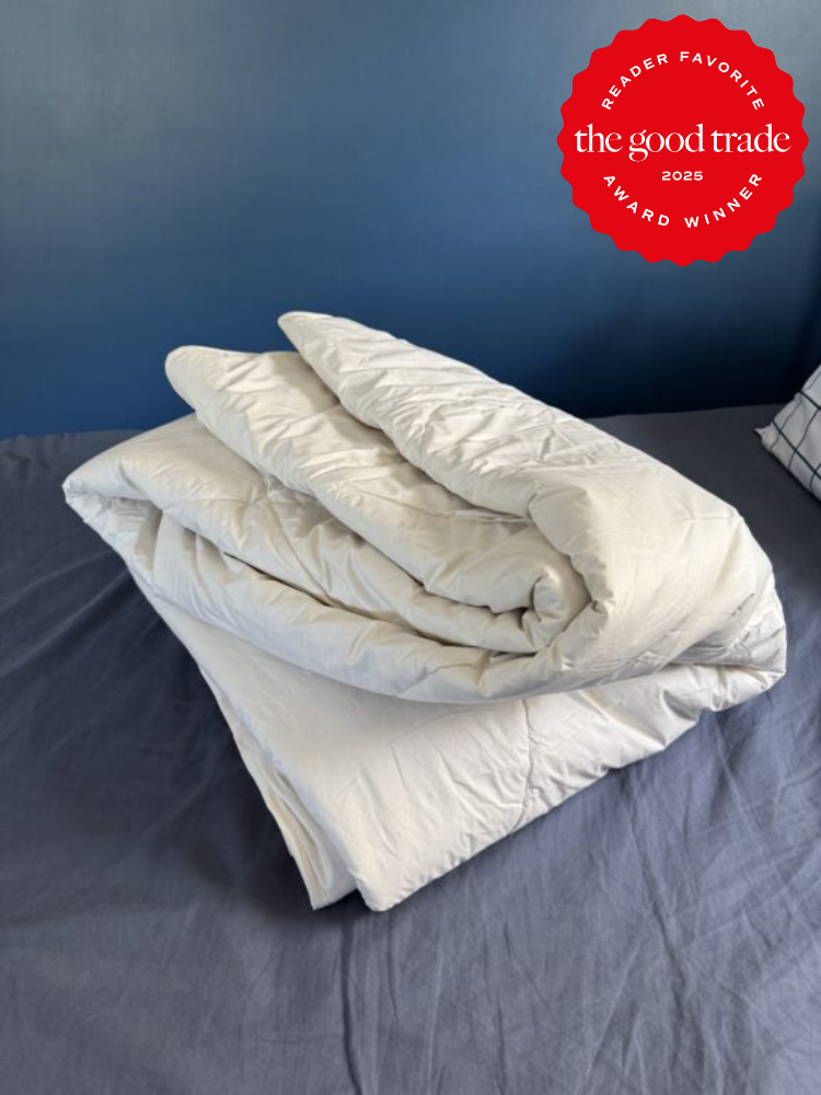 Folded white blanket on a bed with a blue wall in the background. A red badge reads "Reader Favorite the good trade 2025 Award Winner.