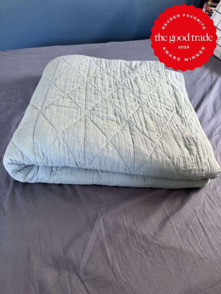 Folded quilt on a bed with an award badge in the corner reading "Reader Favorite, the good trade, 2025 Award Winner.