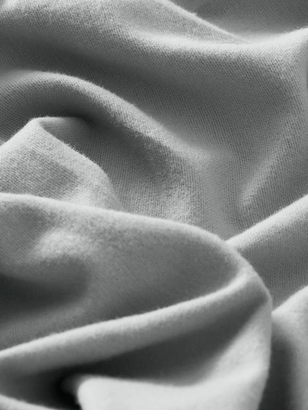 Close-up of gray, crumpled fabric showing waves and shadows.