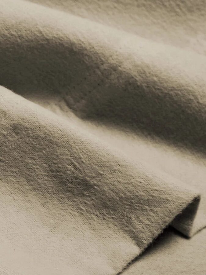 Close-up of folded beige fabric showing texture and stitching.