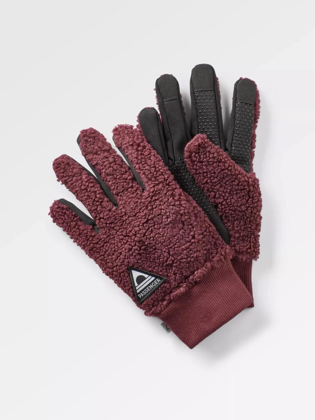 A pair of maroon fleece gloves with black non-slip grips on the palms and fingers. A small triangular logo is visible on one glove.