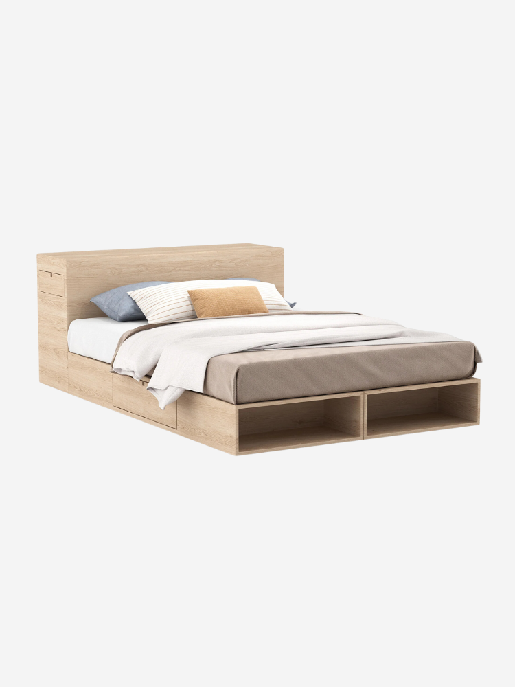 A wooden bed with a headboard, twin pillows, and a beige comforter, featuring storage compartments underneath.