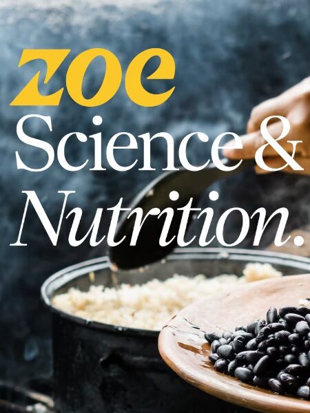 A person serves food onto a plate with rice, black beans, and vegetables. The text reads "Zoe Science & Nutrition." Wood and a bowl are visible in the background.