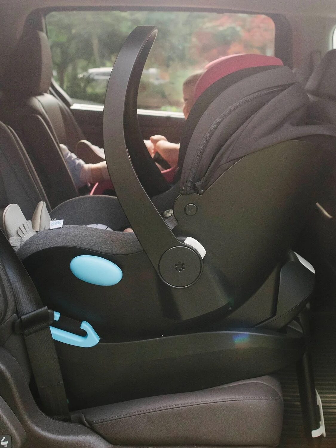 Infant car seat securely installed in the back seat of a vehicle, with a baby inside.
