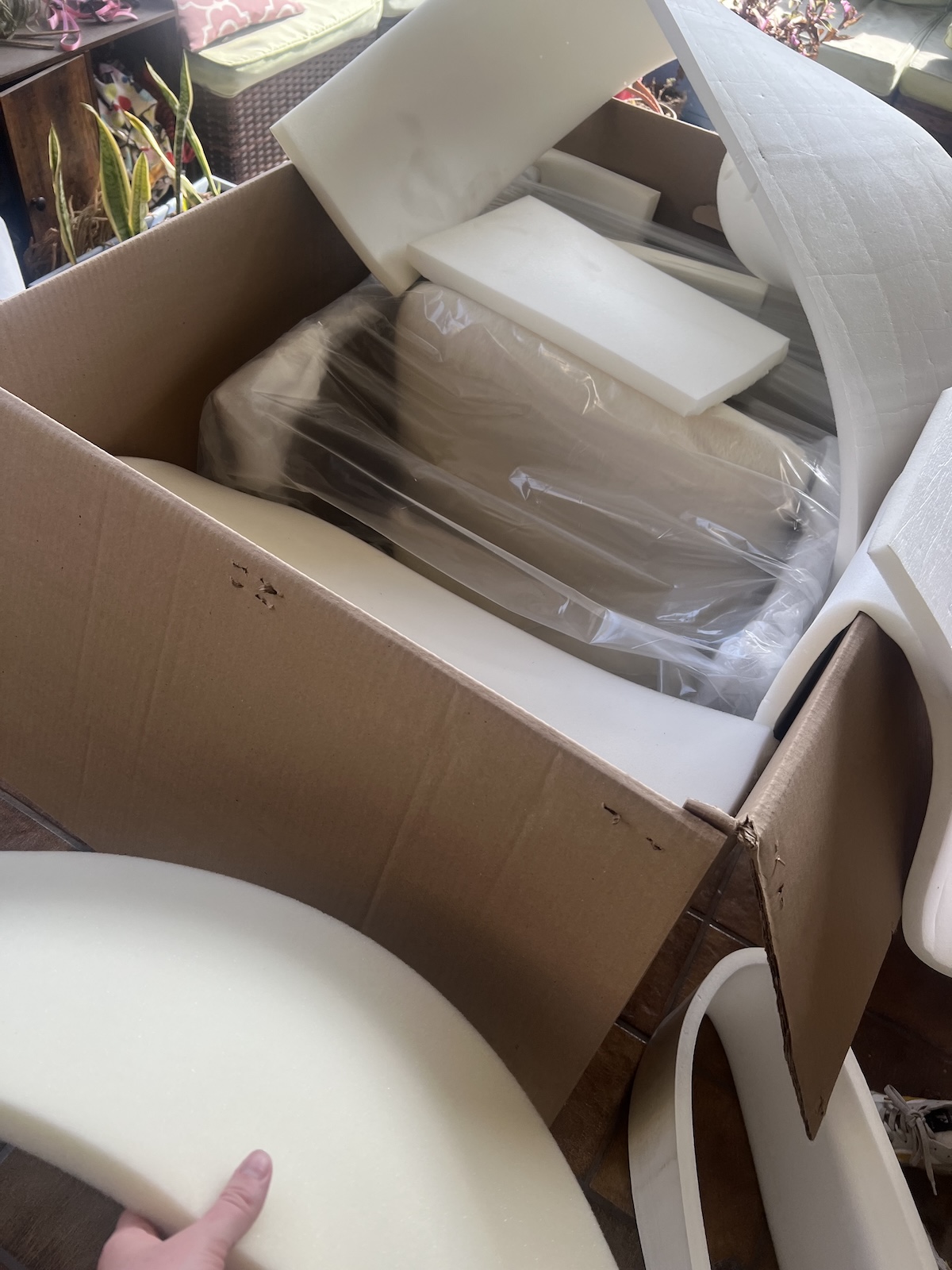 A cardboard box filled with sheets of white packing foam.