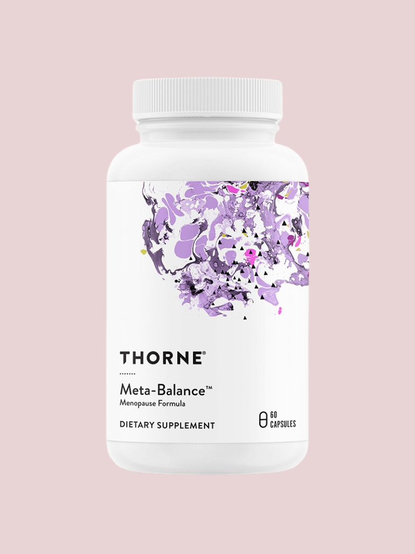A bottle of Thorne Meta-Balance menopause formula dietary supplement with 60 capsules, featuring a purple abstract design on a light pink background.