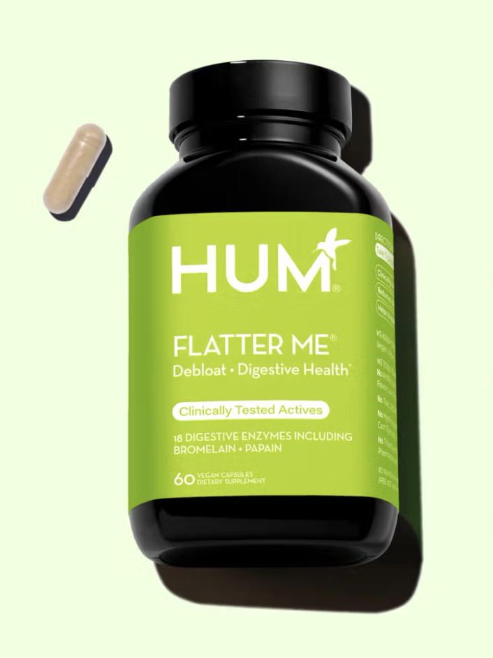 Bottle of HUM Flatter Me capsules with one capsule beside it, labeled for digestive health and bloat relief.