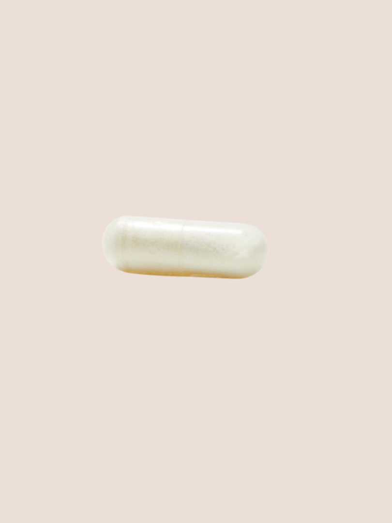 A single white capsule on a light beige background.