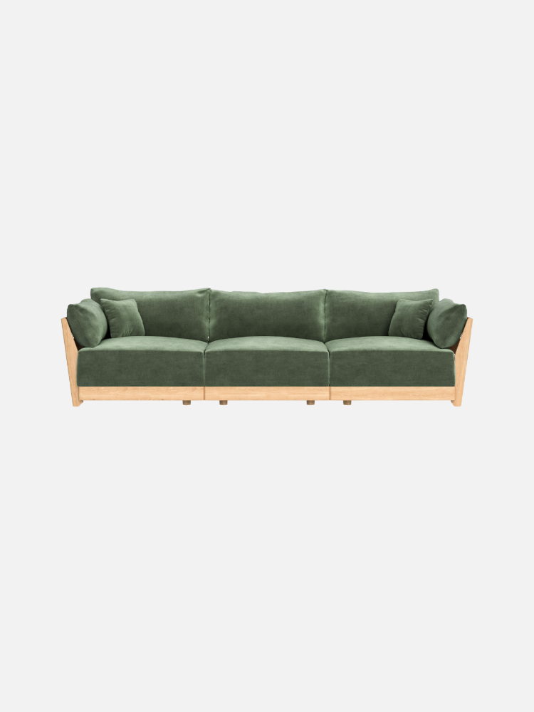 Green velvet sofa with wooden frame and three cushions, viewed from the front against a plain white background.