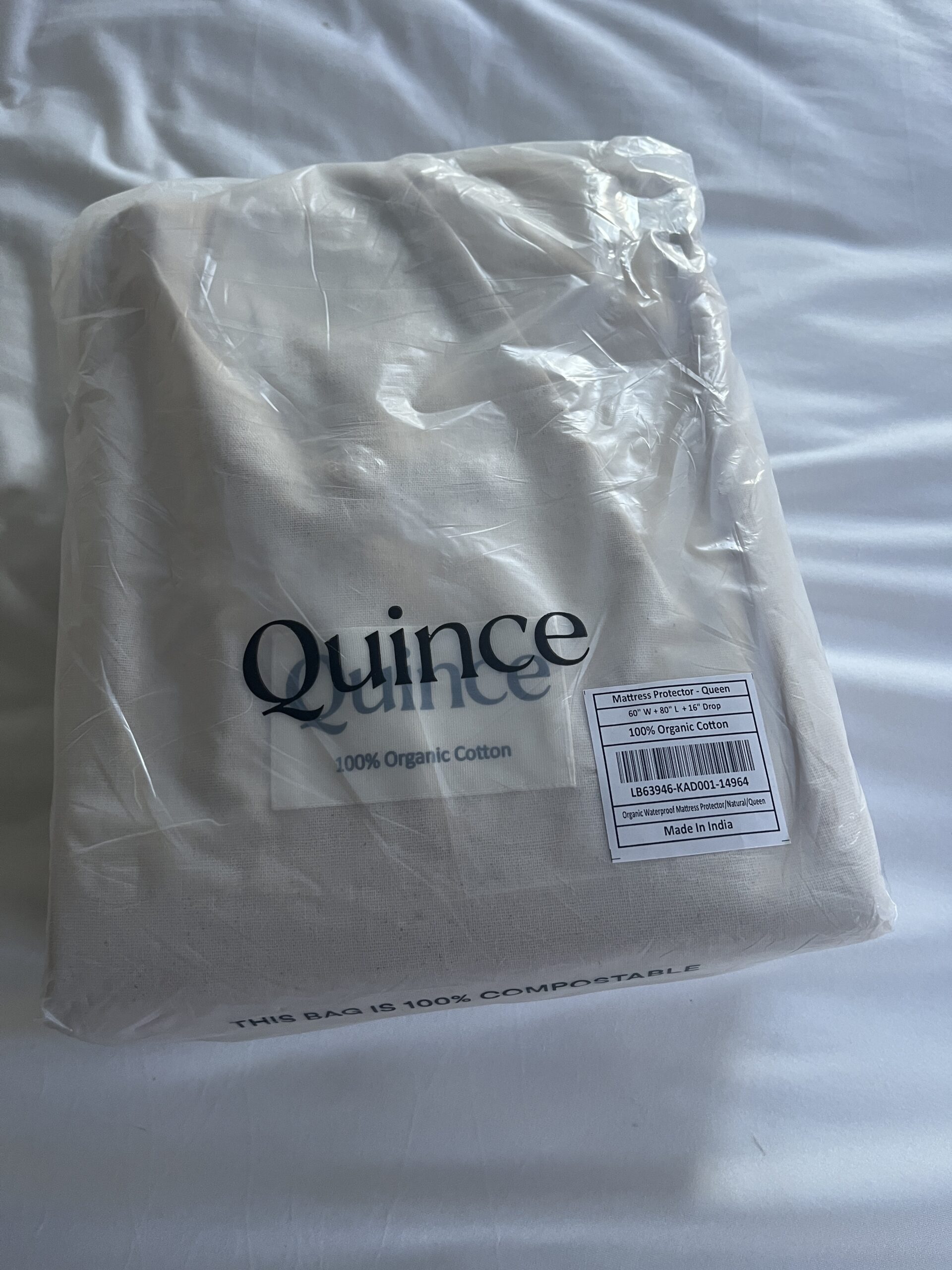 Packaged Quince bedding set on a white surface, labeled as 100% organic cotton, made in India.