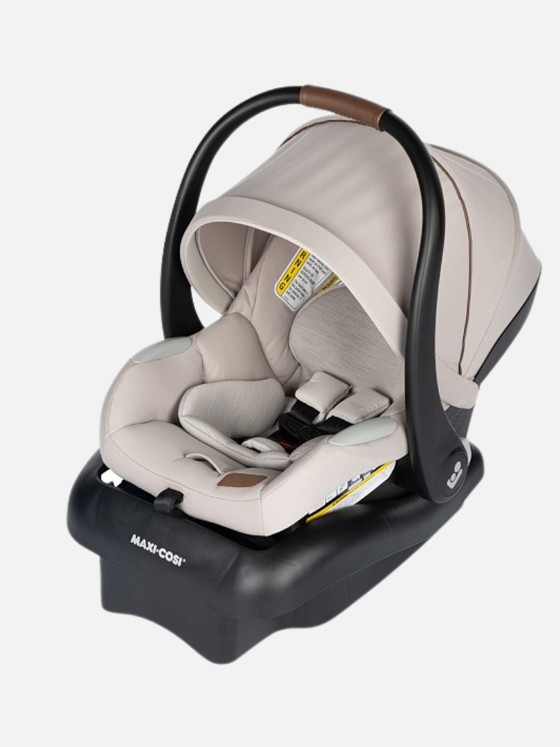 Beige infant car seat with a black base, adjustable canopy, and safety harness on a white background.