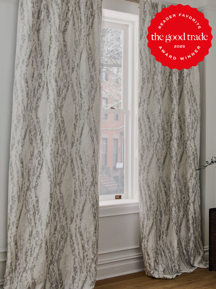 A window with light gray patterned curtains. A red award badge in the top right corner reads "Reader Favorite The Good Trade Award Winner 2025.