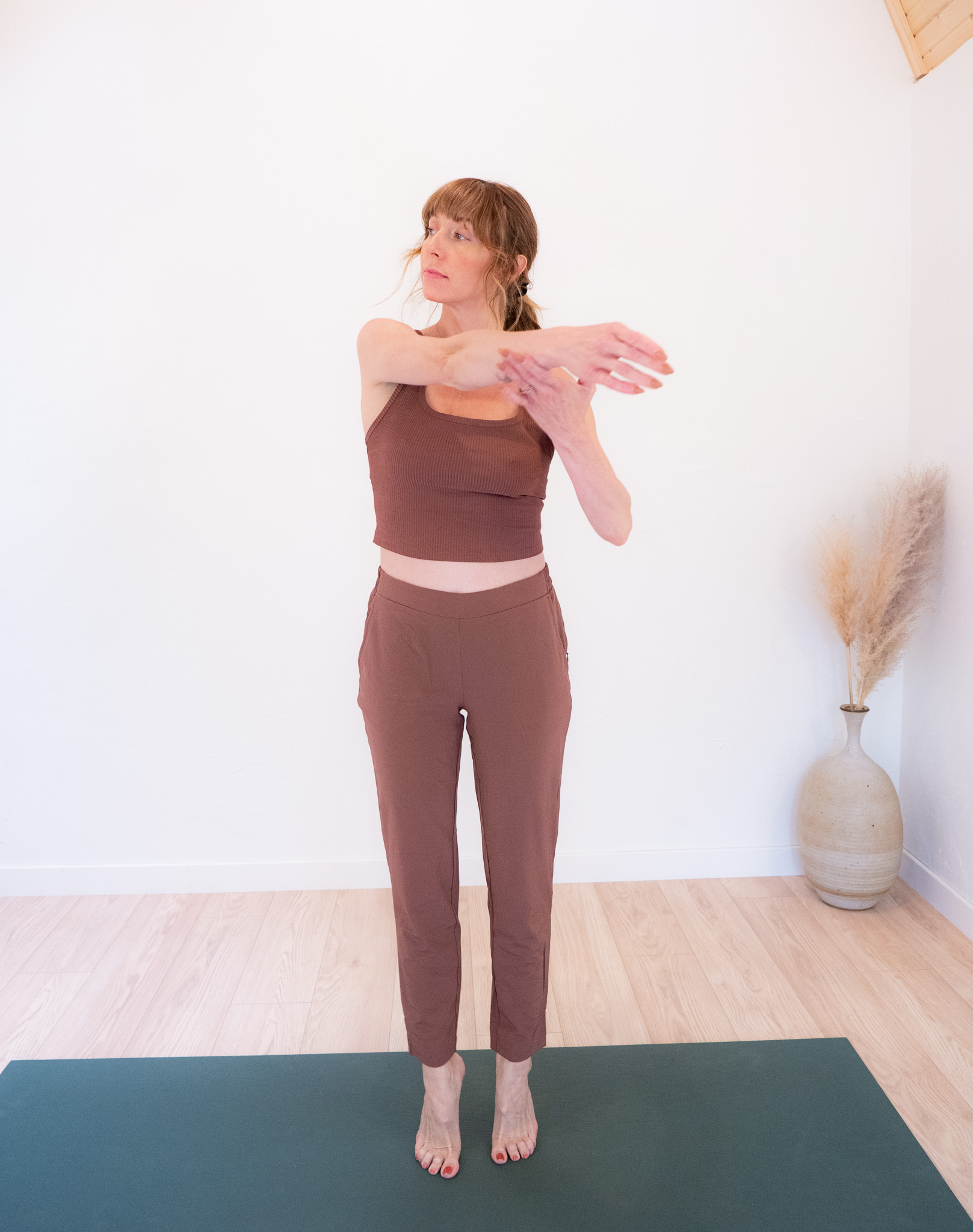 TGT editor on a yoga mat, wearing a brown matching loungewear set from tentree. 