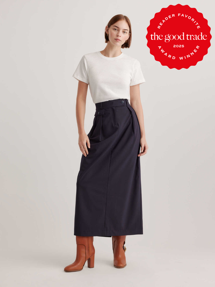 Person wearing a white T-shirt, long dark skirt, and brown boots. A "Reader Favorite" award badge from The Good Trade is in the top right corner.