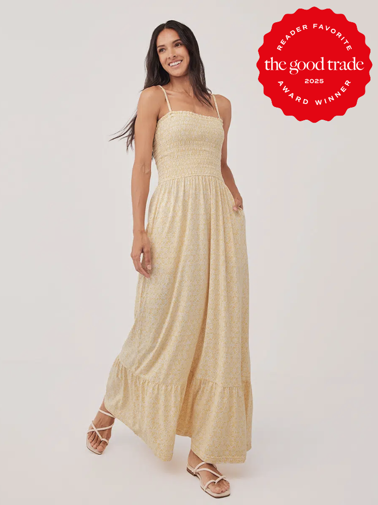 A woman in a light yellow maxi dress with thin straps poses against a plain background. A "The Good Trade 2025 Award Winner" badge is visible in the upper right corner.