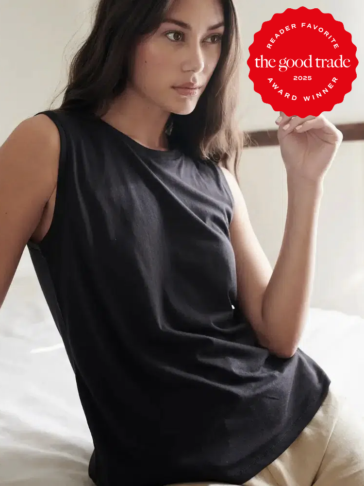 Person wearing a black sleeveless top sits on a bed. A red award badge in the corner reads "Reader Favorite The Good Trade 2025 Award Winner.