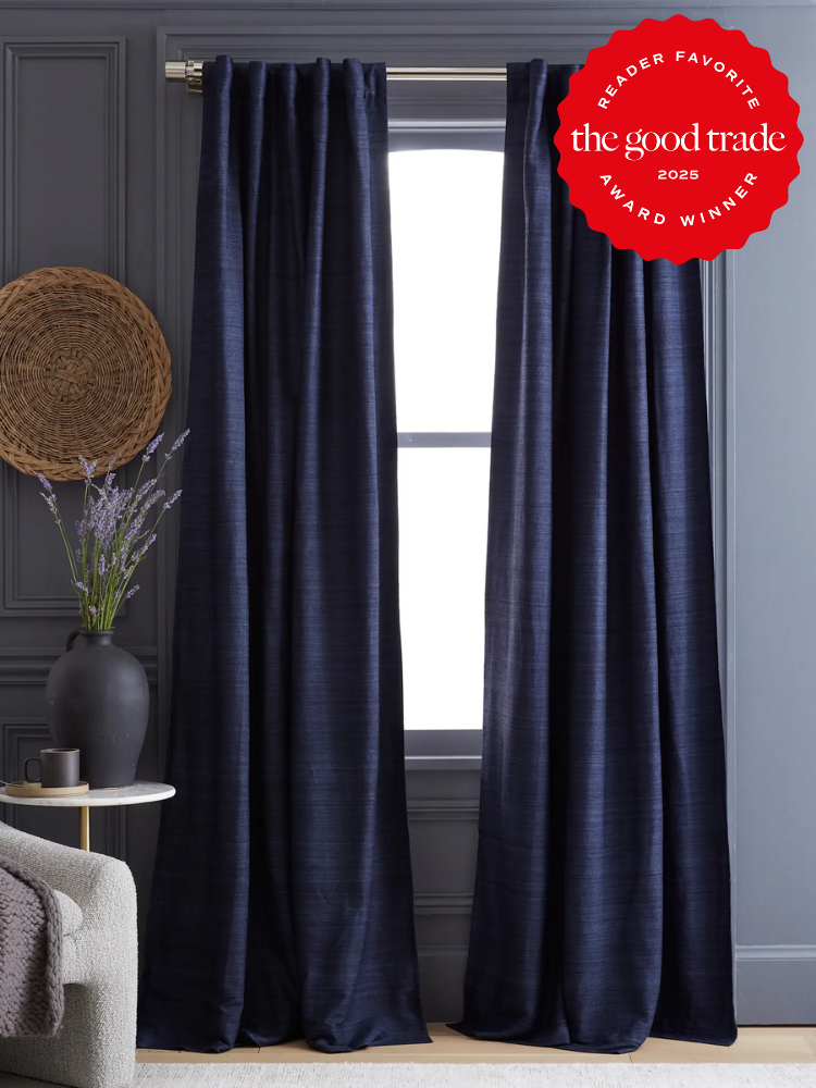 Dark blue curtains hang in a room with gray walls, a woven basket, and a vase with lavender. A red award badge is displayed in the top right corner.