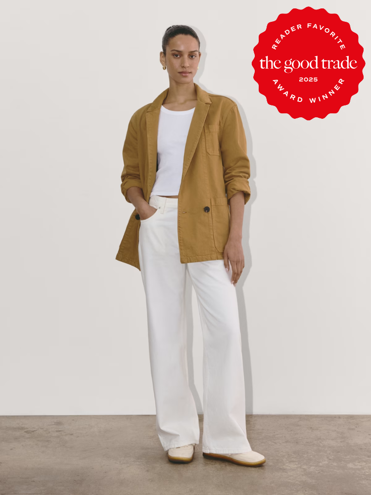 A person wearing a tan blazer, white shirt, and white trousers stands against a plain background. A red badge reads "Reader Favorite the good trade 2023 Award Winner.