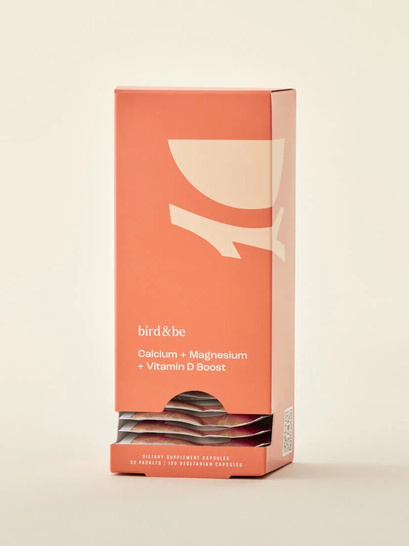 A peach-colored box labeled "bird & be" containing individual packets of calcium, magnesium, and vitamin D supplements is displayed against a plain background.
