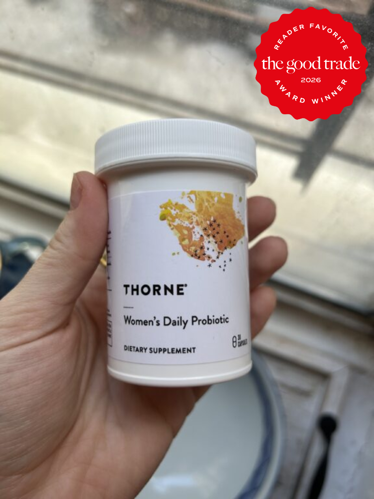 A hand holds a container of Thorne Women's Daily Probiotic dietary supplement. A red award badge for "The Good Trade Reader Favorite 2026" is in the top right corner.