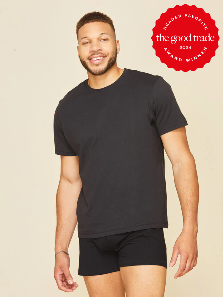 A man wearing a black t-shirt and black boxer briefs stands against a plain background. A red badge in the corner reads, “Reader Favorite, The Good Trade, Award Winner 2024.”.