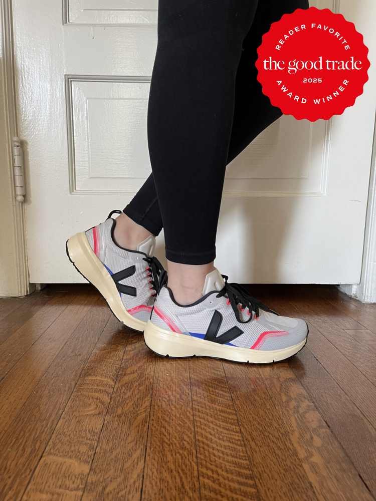 Person wearing gray athletic sneakers with black and red accents, standing on a wooden floor. A "Reader Favorite" award badge is visible in the top right corner.