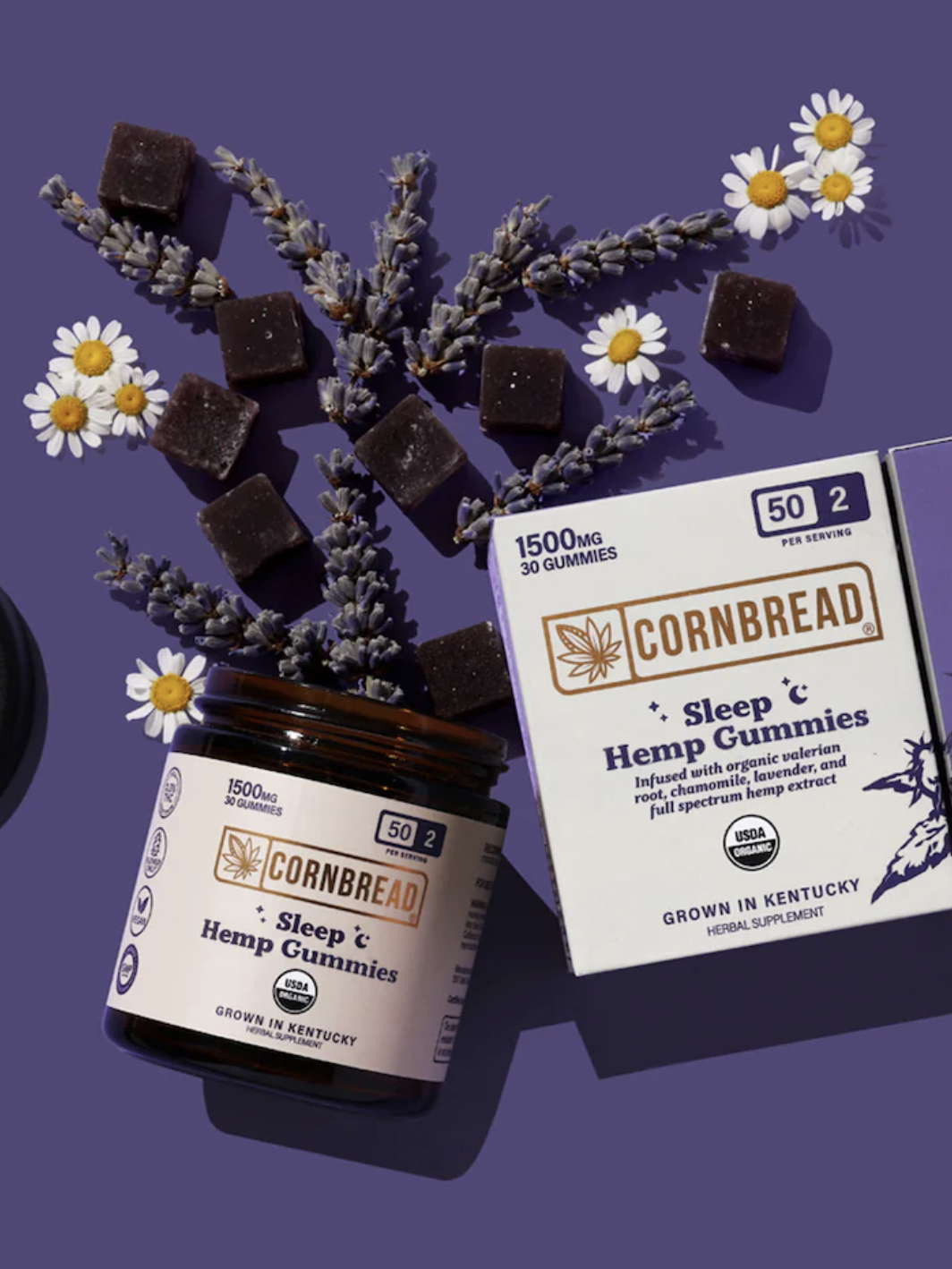 A jar and box of Cornbread Hemp Sleep Gummies are arranged with lavender sprigs, chamomile flowers, and several gummies on a purple background.