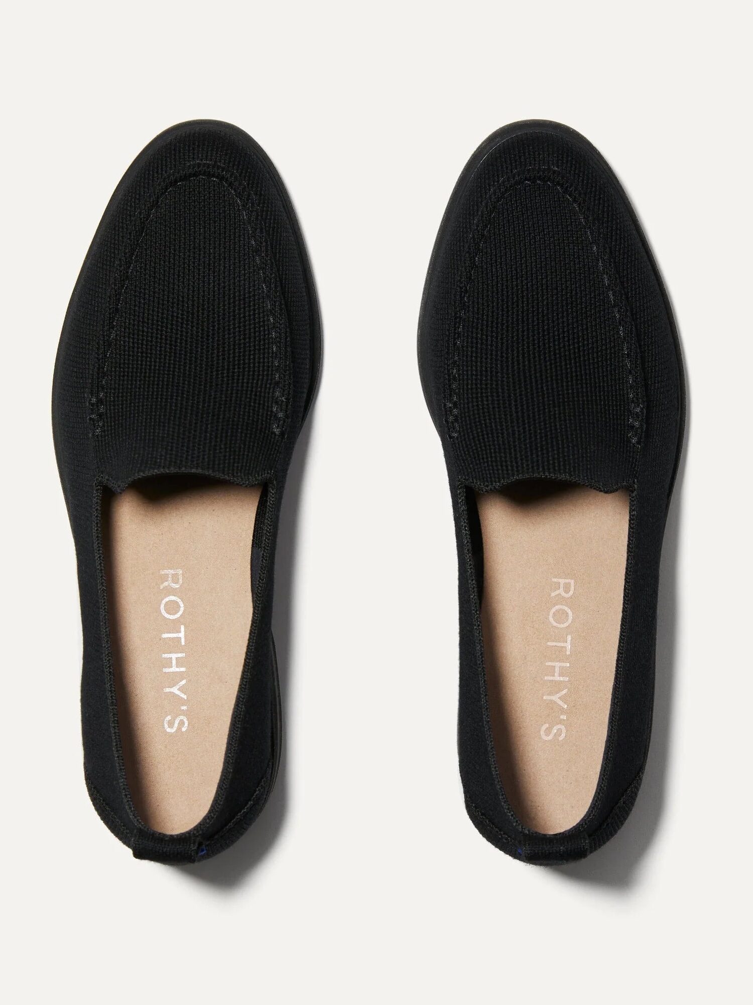 Black loafers with visible stitching, viewed from above. "Rothy's" printed inside each shoe on the insole.