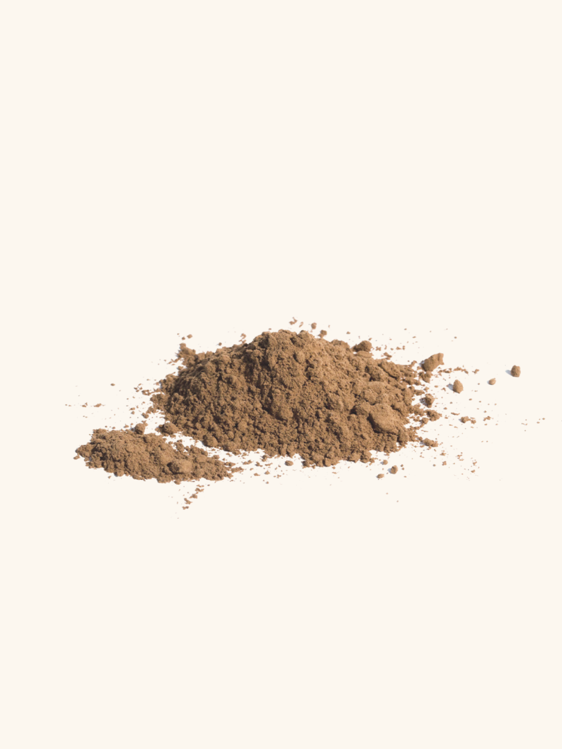 A small pile of light brown powder on a plain, off-white background.