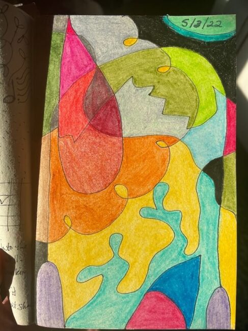 Abstract drawing with overlapping, colorful shapes in yellow, blue, red, orange, green, and black. Date "5/13/22" written in the top right corner. Sunlight shines on the page.