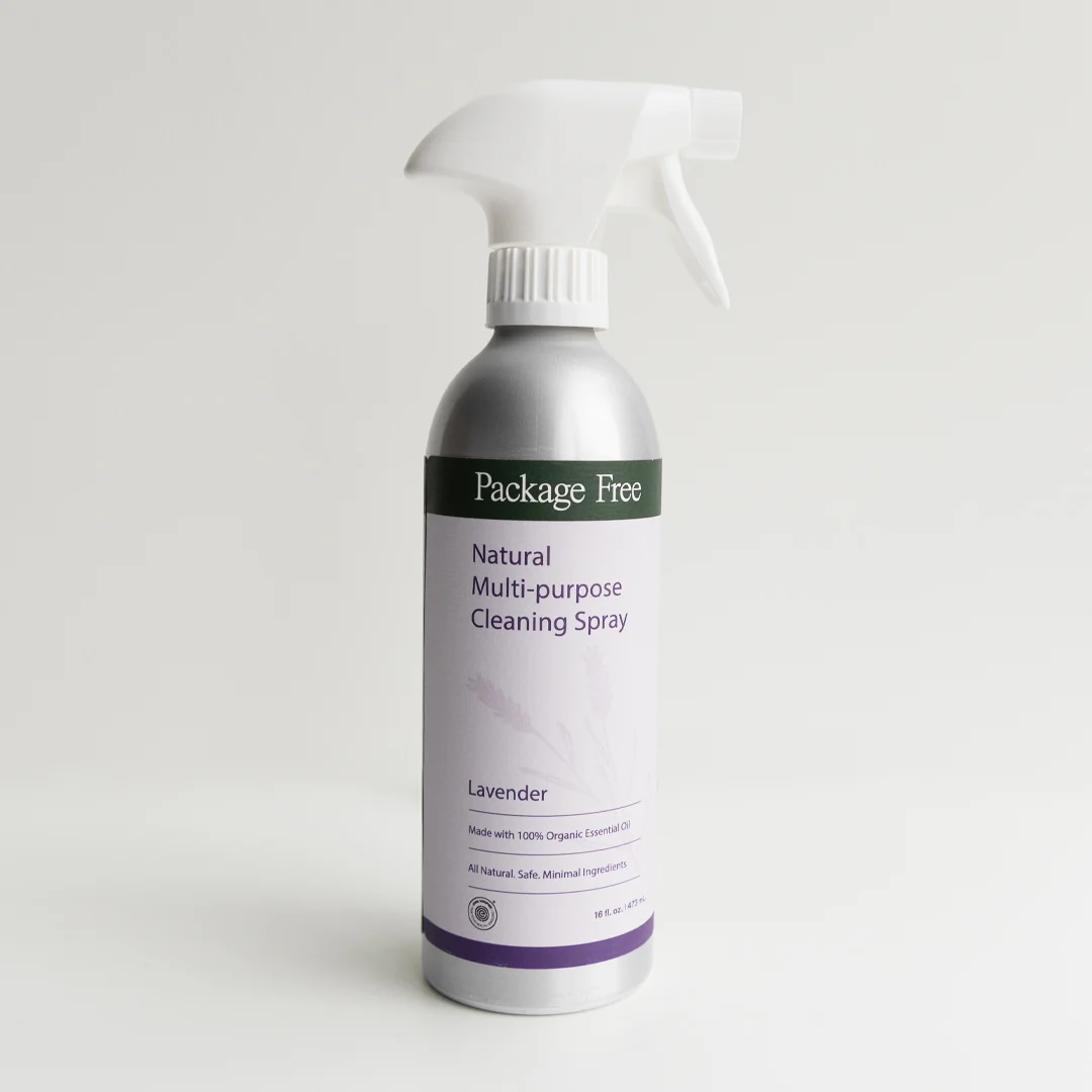 A bottle of Package Free Natural Multi-purpose Cleaning Spray with lavender scent, featuring a white spray nozzle and a light purple label on a plain background.