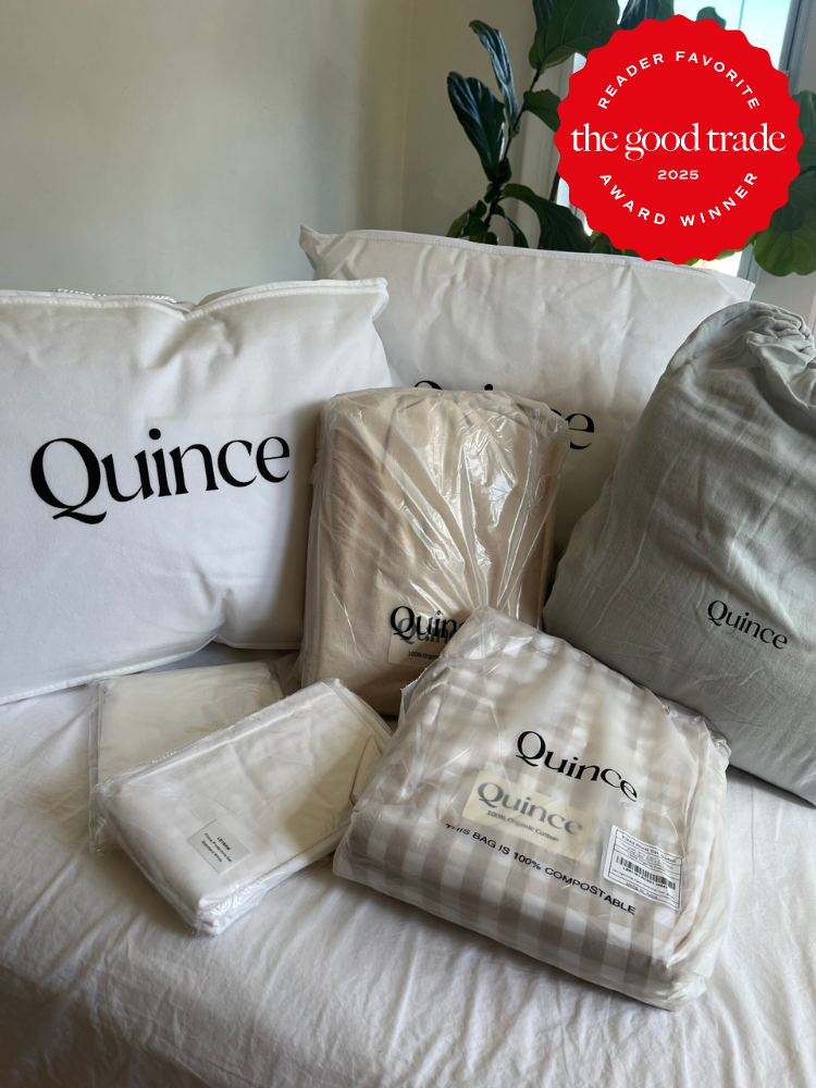 A collection of Quince bedding products, including pillows and sheets, arranged on a bed, with a "The Good Trade 2025 Reader Favorite Award Winner" badge in the corner.