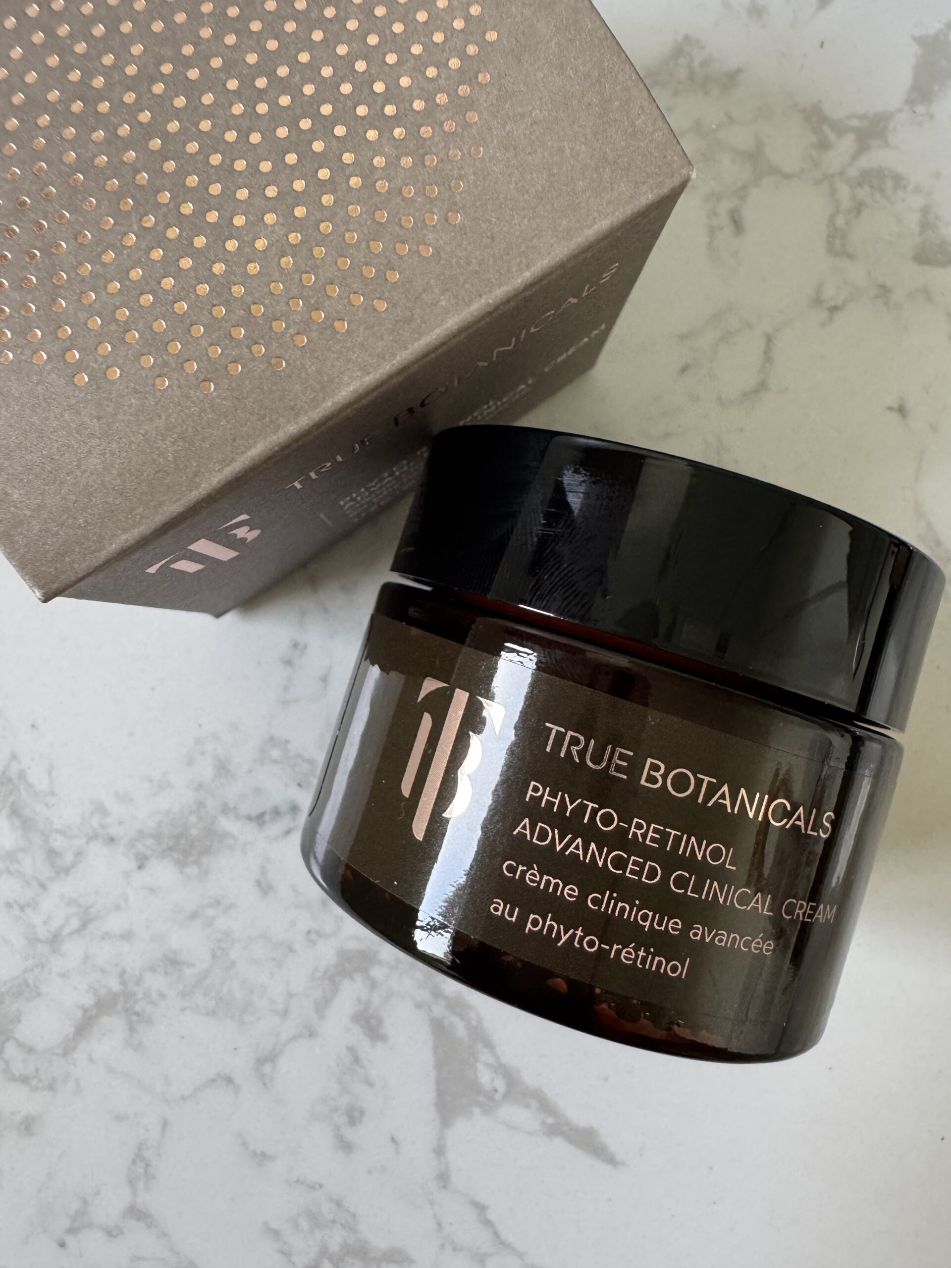 A jar of True Botanicals Phyto-Retinol Advanced Clinical Cream sits on a white surface next to its matching product box.