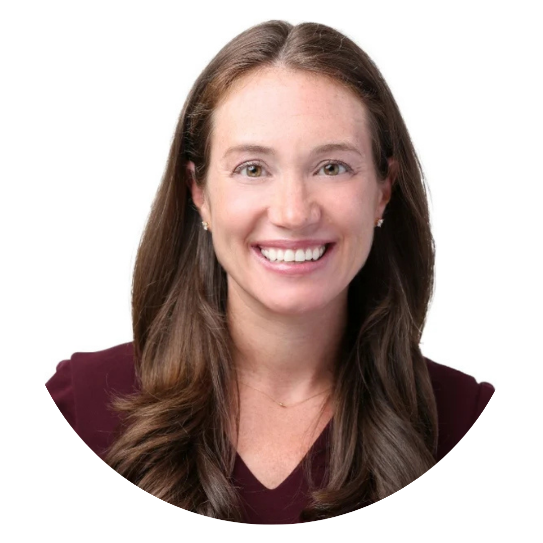 Woman with long brown hair and a burgundy top smiles at the camera, posed against a plain white background.