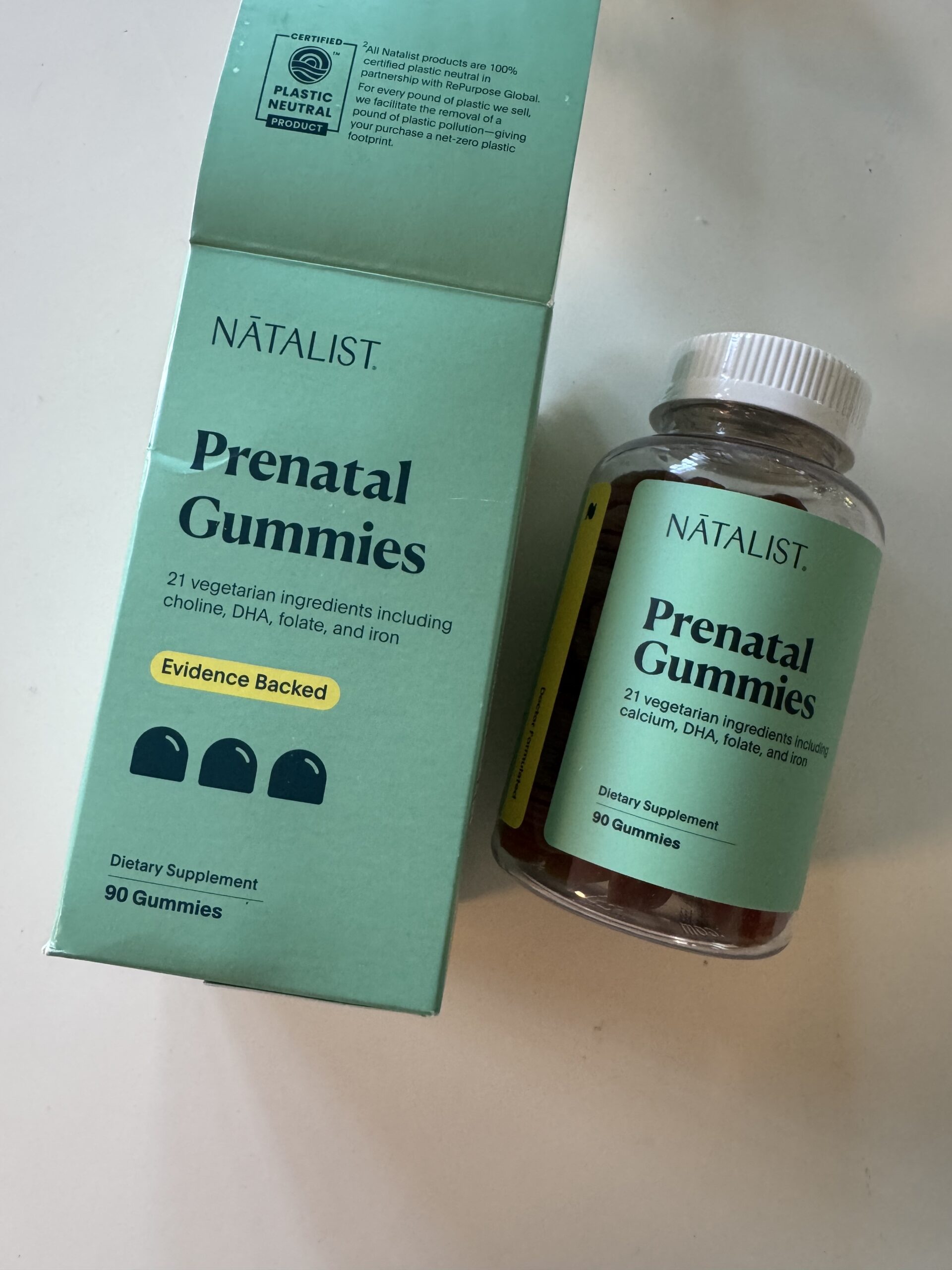 A box and bottle of Natalist Prenatal Gummies are shown, labeled as prenatal vitamin dietary supplements containing 90 vegetarian gummies.