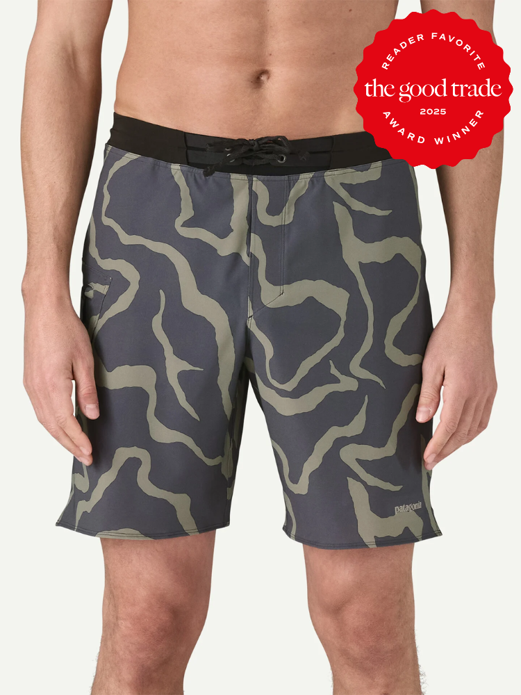 A person wearing gray and olive green patterned board shorts with a black waistband; a "The Good Trade 2025 Award Winner" badge is in the top right corner.