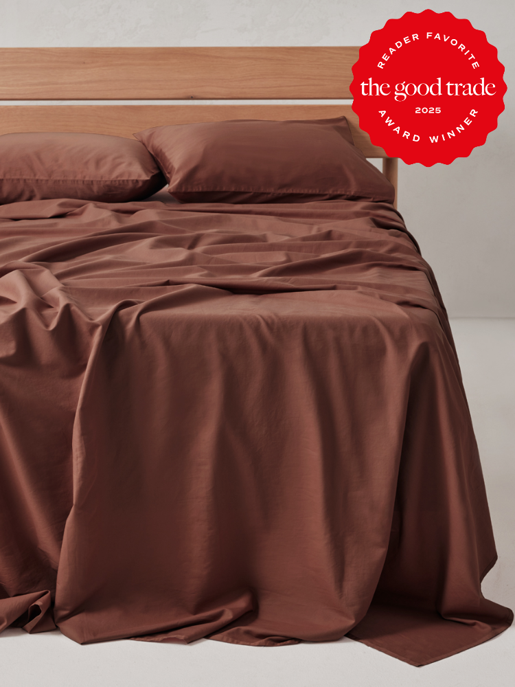 A neatly made bed with brown sheets and pillows, draped over the sides, with a “Reader Favorite The Good Trade Award Winner 2025” badge in the top right corner.