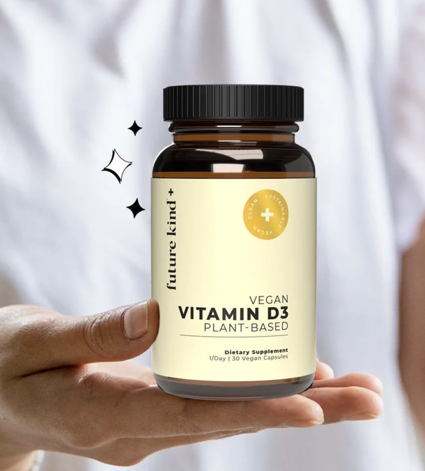 A person holds a bottle of Future Kind+ Vegan Vitamin D3 Plant-Based dietary supplement with 120 vegan capsules.