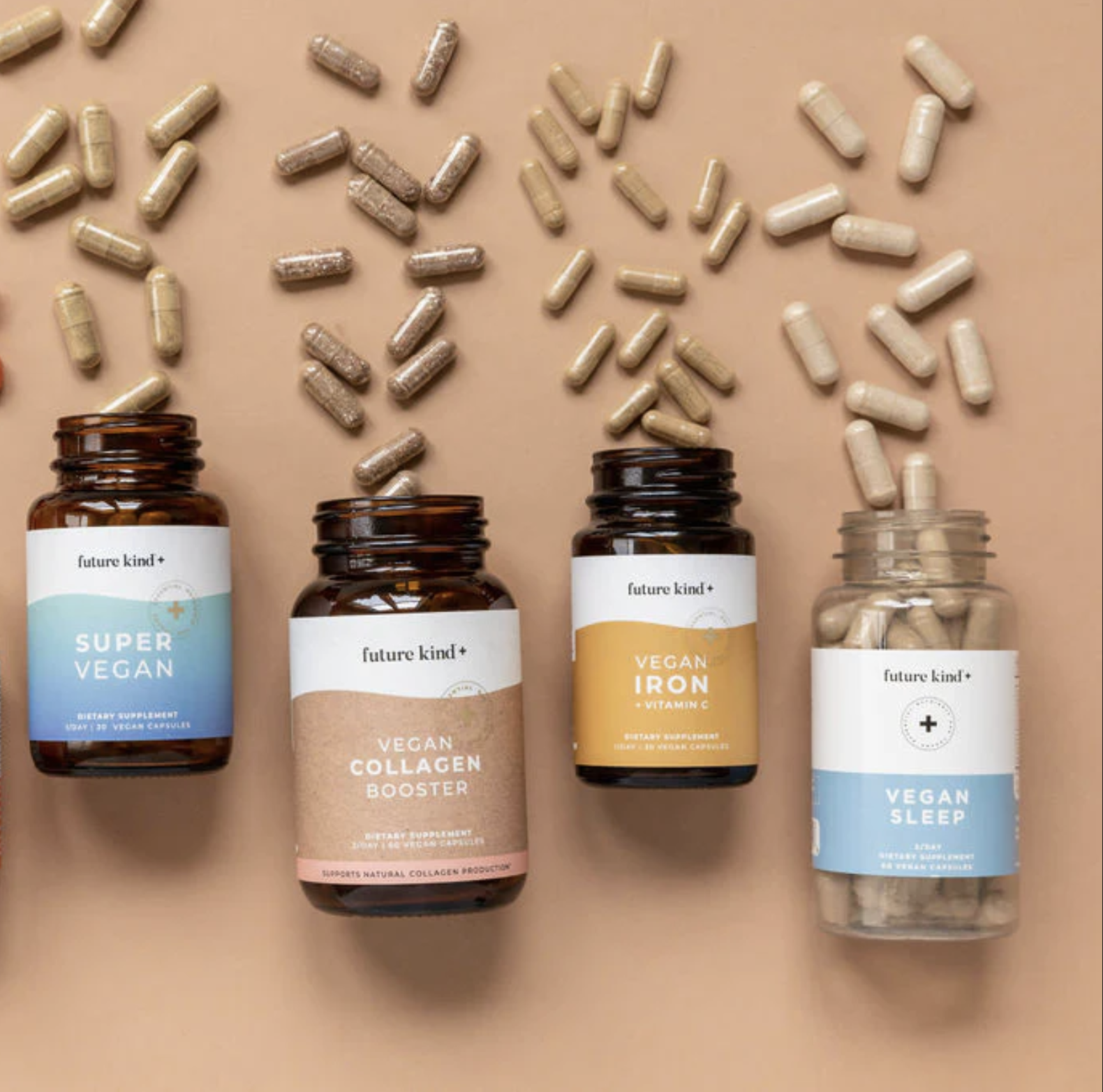 Four bottles of vegan dietary supplements and scattered capsules are displayed on a beige background. The bottles are labeled Super Vegan, Collagen Booster, Iron, and Sleep.