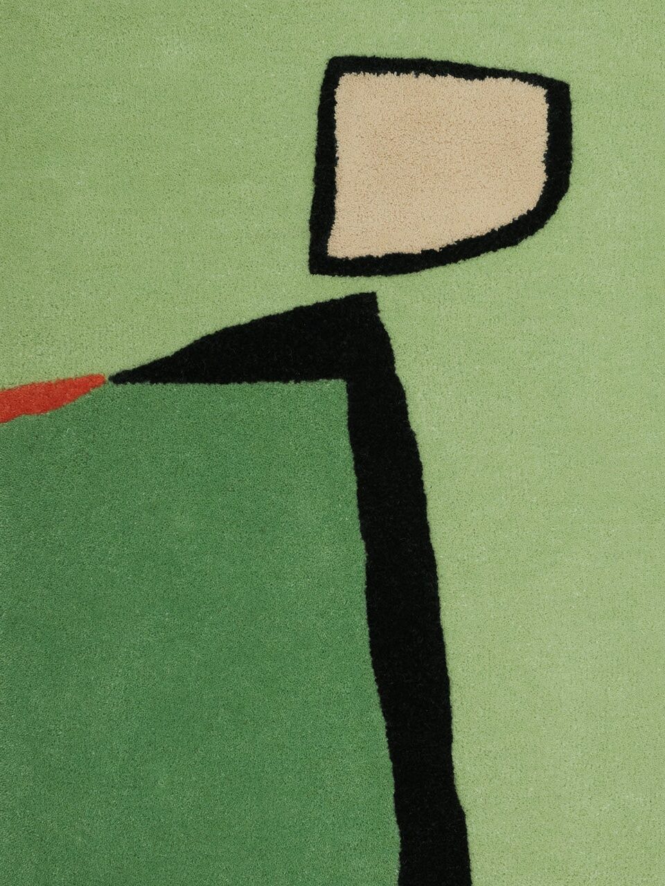 Rectangular rug with an abstract design featuring light green, dark green, beige, black, and a small red section on a flat, plain background.