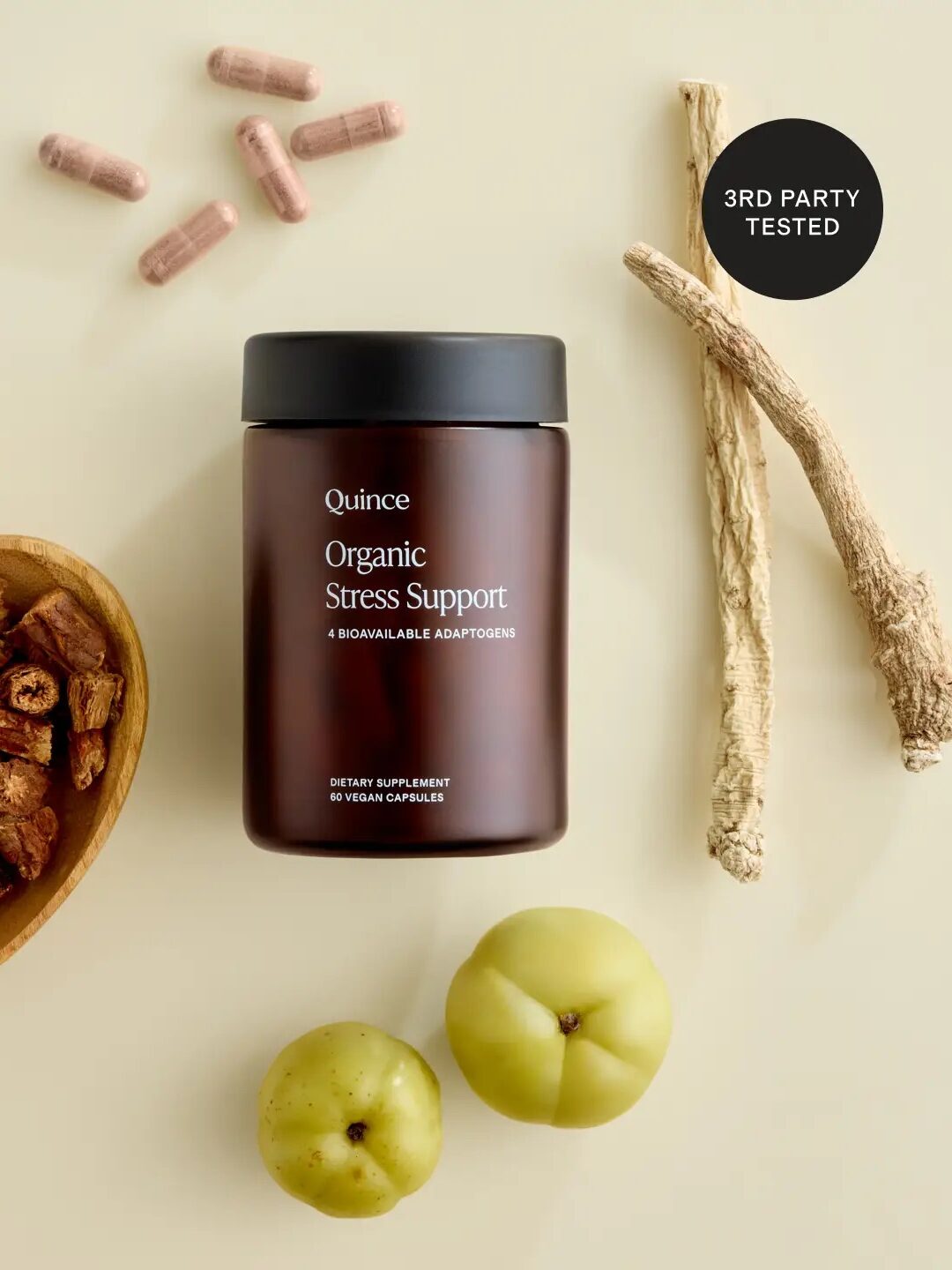 A jar labeled "Quince Organic Stress Support" sits beside capsules, dried herbs, two roots, and two green fruits on a light surface. A badge reads "3rd Party Tested.