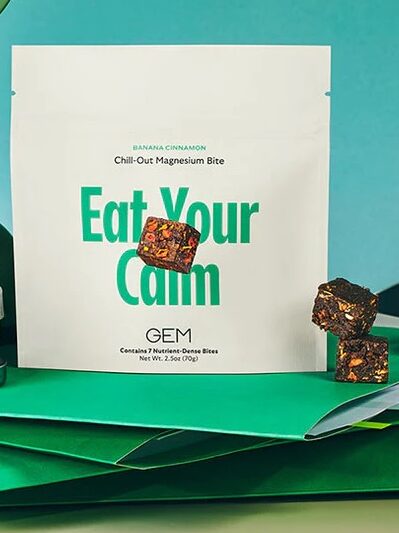 A pouch labeled "Eat Your Calm" stands on a desk with scattered office items, a green phone receiver, scattered cubes, and a "TARGETED SUPPORT" label in the corner.